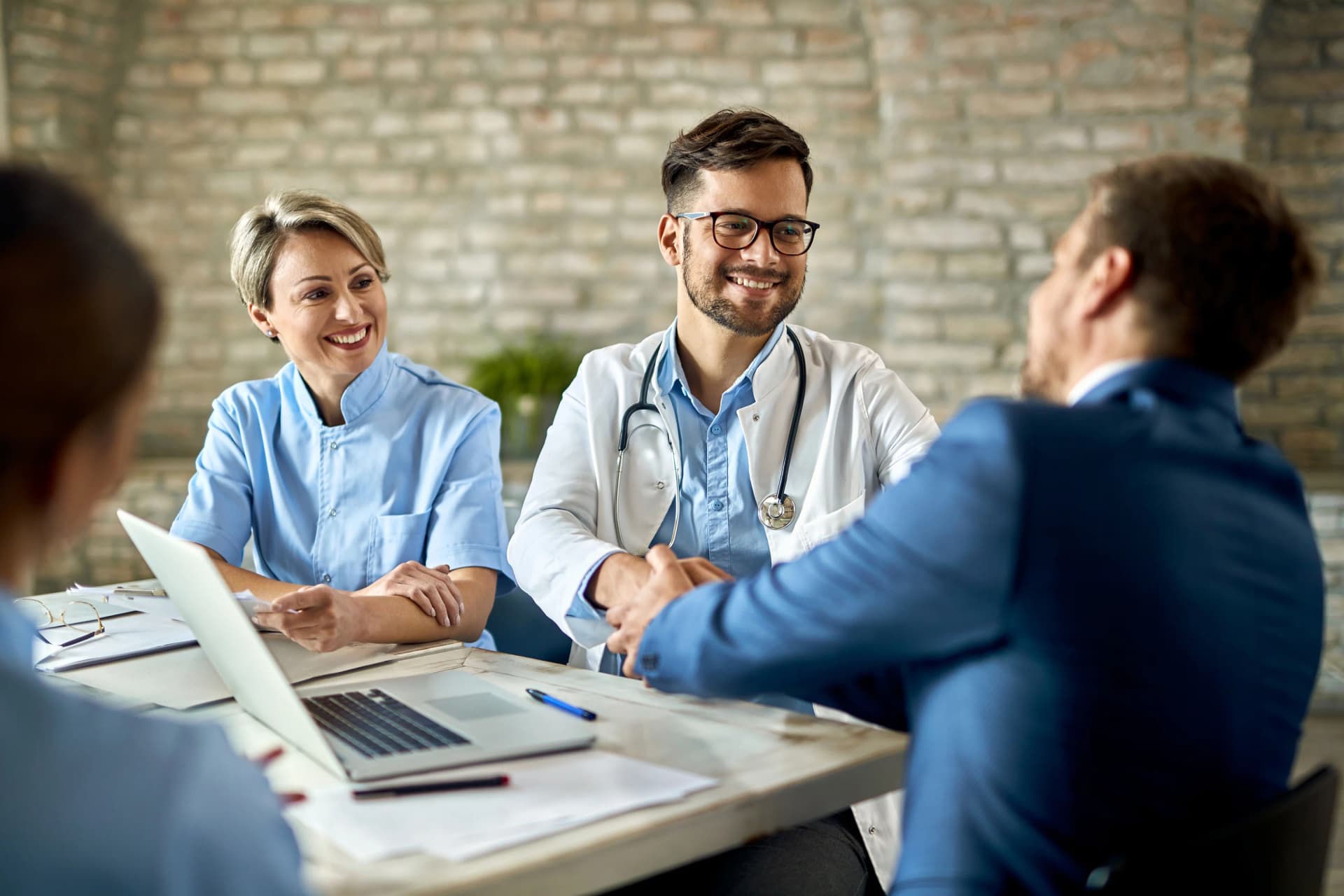Doctors and patient in consultation at a sunlit clinical desk